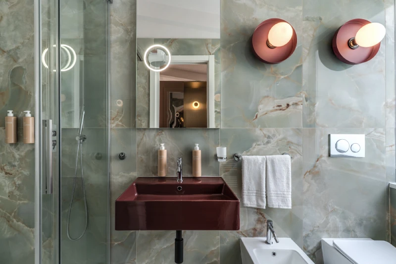 Elegant bathroom detail with modern sink, illuminated mirror and marble-effect tiles near Palazzo Barberini - Barberini 16, BZAR hotels in Rome