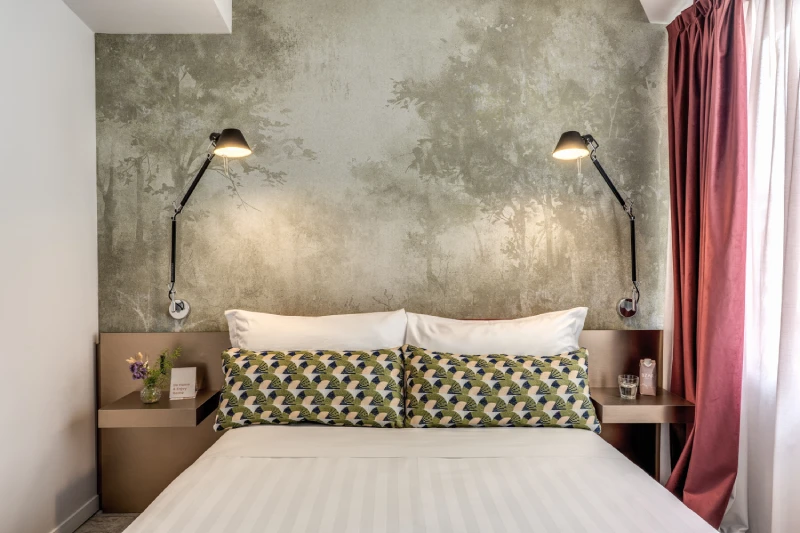 Double bed detail with decorative cushions and modern lighting in room near Palazzo Barberini in Rome - Barberini 16, BZAR hotels in Rome
