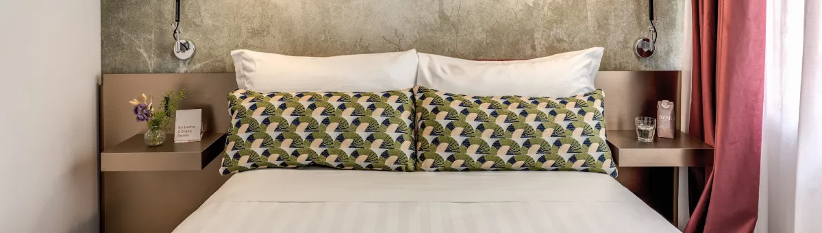 Double bed detail with decorative cushions and modern lighting in room near Palazzo Barberini in Rome - Barberini 16, BZAR hotels in Rome