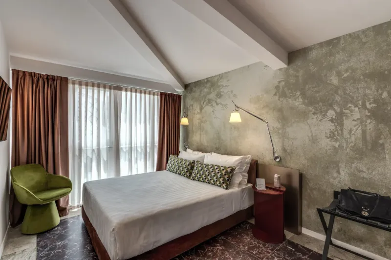 Modern Junior Suite with double bed, green armchair and large bright window in central Rome - Barberini 16, BZAR hotels in Rome