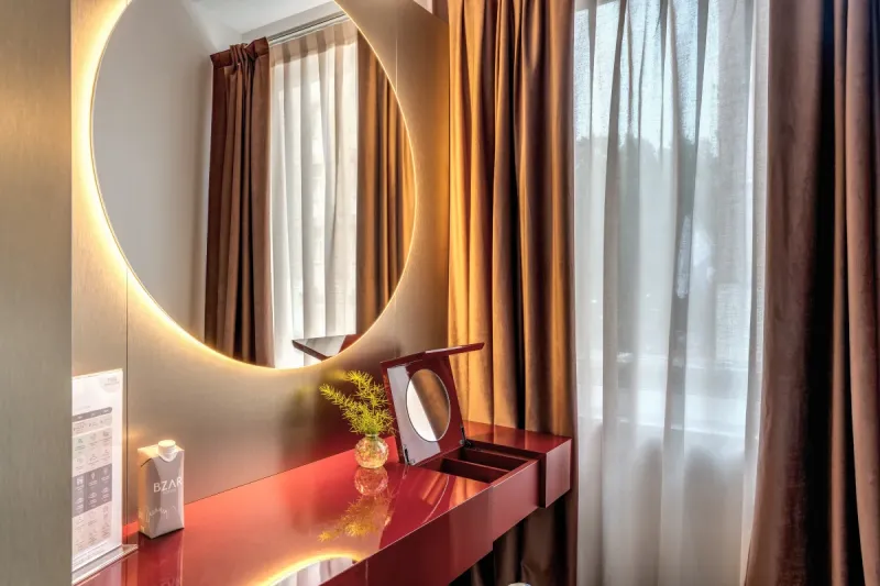 Vanity detail with illuminated round mirror and glossy red surface in Junior Suite in Rome - Barberini 16, BZAR hotels in Rome
