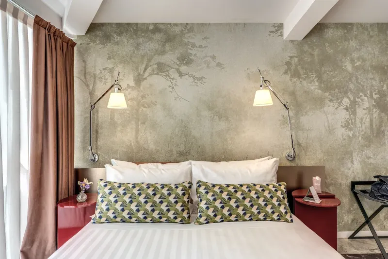 Double bed detail with geometric cushions and reading lights in design Junior Suite in Rome - Barberini 16, BZAR hotels in Rome